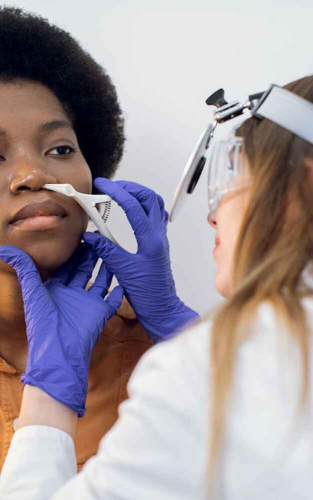 ENT doctor examining inside patient's nose