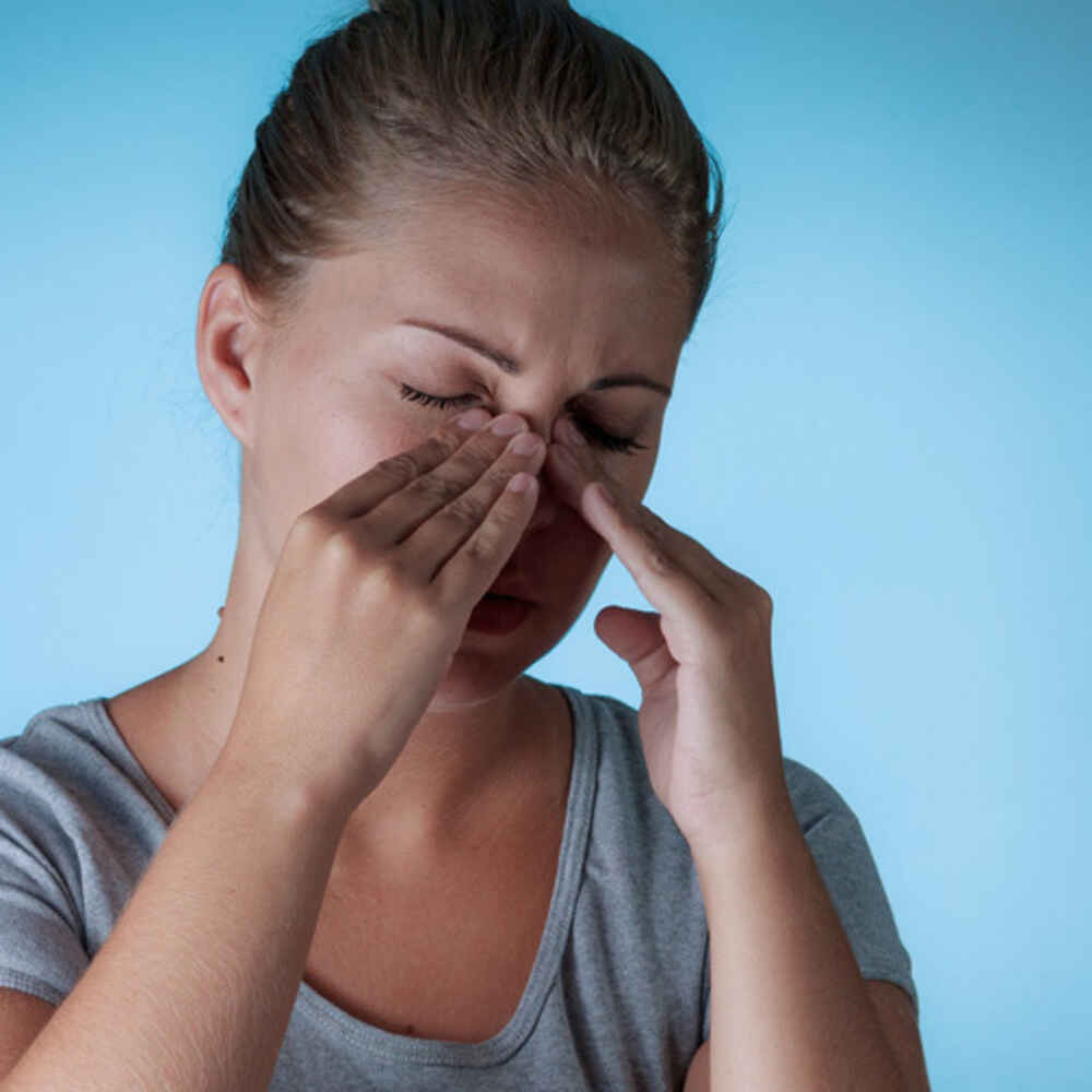 Women pressing her fingers on her nose due to nasal or sinus issues