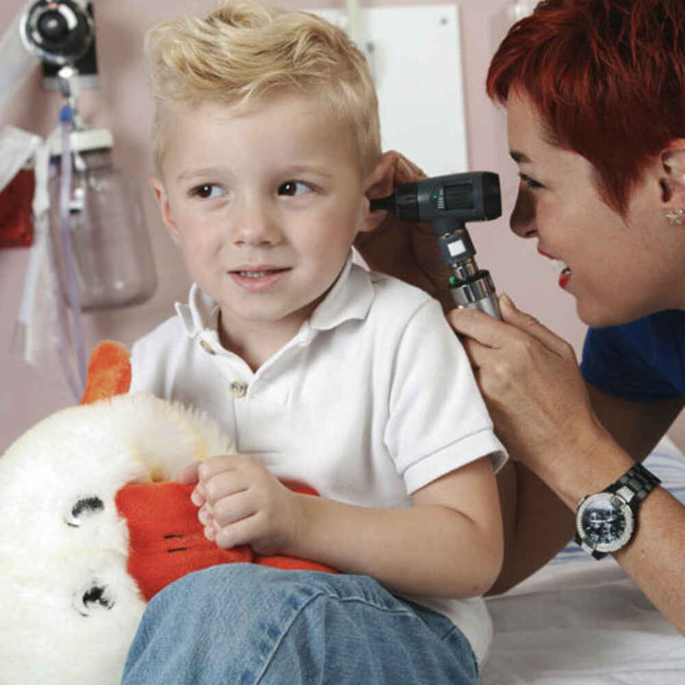 ENT doctor checking child's ear for earwax buildup