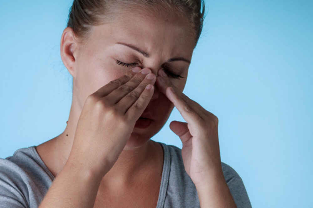 Women pressing her fingers on her nose due to nasal or sinus issues