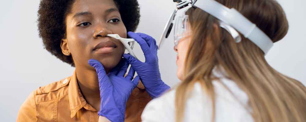 ENT doctor examining inside patient's nose